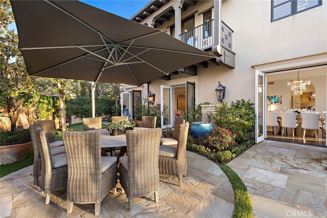 view of patio featuring a balcony and outdoor dining area