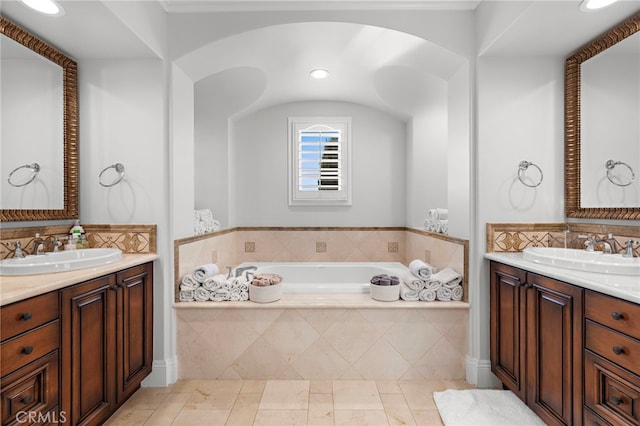 bathroom with tile patterned flooring, two vanities, a sink, and a bath