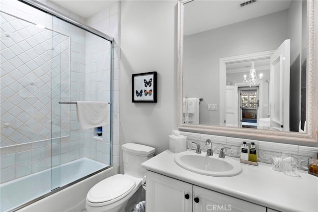 full bathroom featuring visible vents, toilet, ornamental molding, combined bath / shower with glass door, and vanity