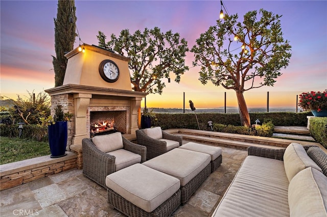 view of patio with an outdoor living space with a fireplace