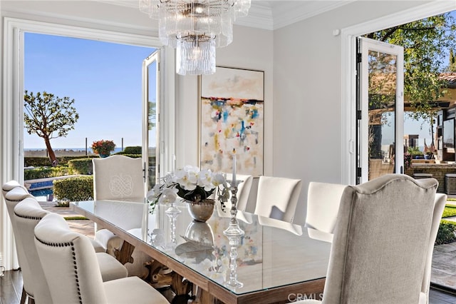 dining area with crown molding, a notable chandelier, and a healthy amount of sunlight