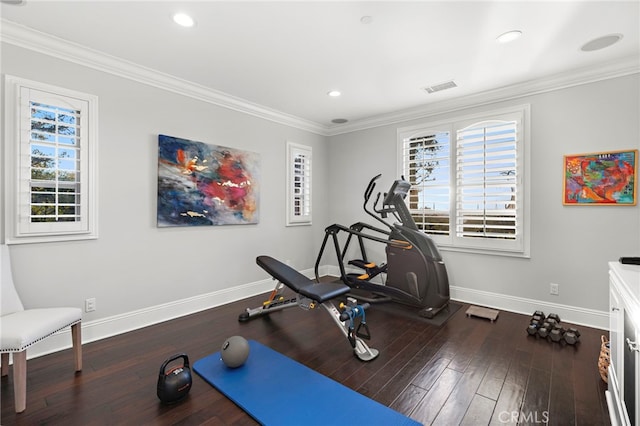 workout area featuring crown molding, visible vents, baseboards, and wood finished floors