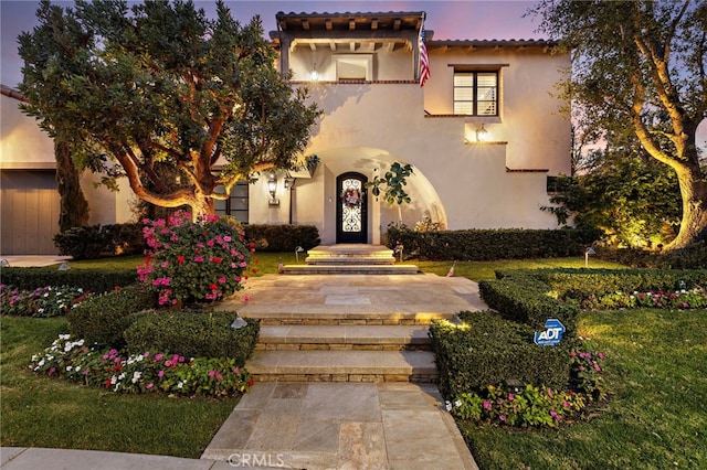 view of front of home with a tile roof and stucco siding