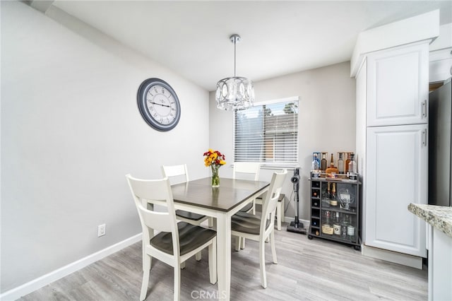 dining area featuring light hardwood / wood-style floors and a notable chandelier