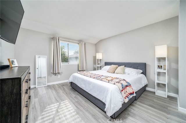 bedroom with light hardwood / wood-style flooring and vaulted ceiling