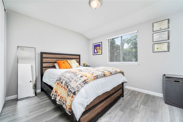 bedroom featuring hardwood / wood-style flooring and vaulted ceiling