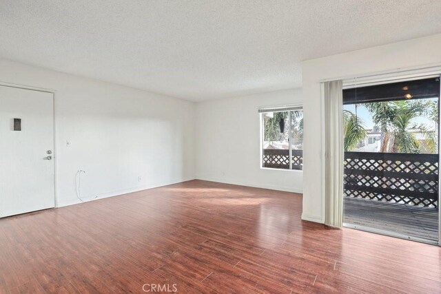 empty room with a textured ceiling and hardwood / wood-style floors