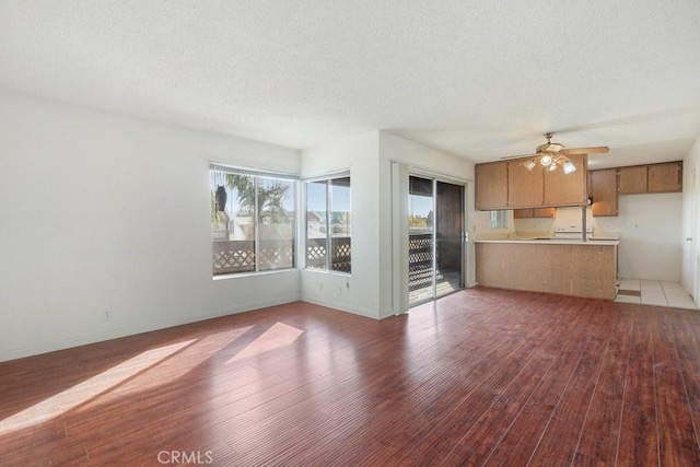 unfurnished living room featuring light hardwood / wood-style floors, a textured ceiling, and ceiling fan