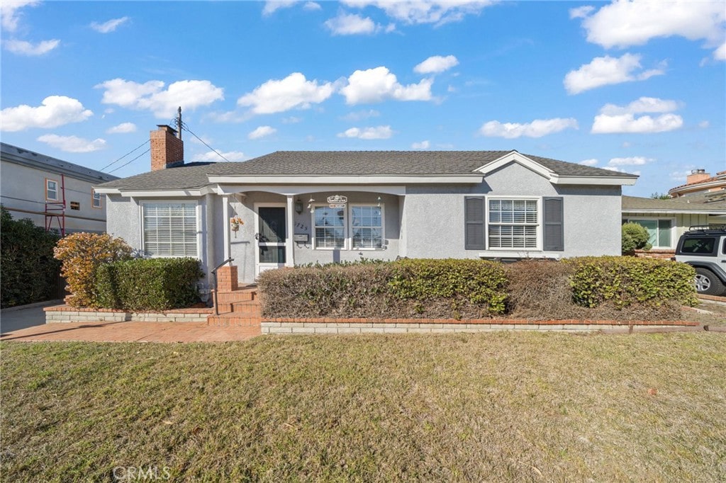 single story home with a front lawn