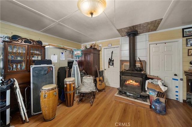 miscellaneous room featuring a wood stove and light hardwood / wood-style floors