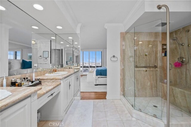 ensuite bathroom with vanity, a stall shower, ornamental molding, tile patterned flooring, and connected bathroom