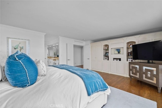 bedroom featuring dark wood-type flooring, ensuite bathroom, and ornamental molding