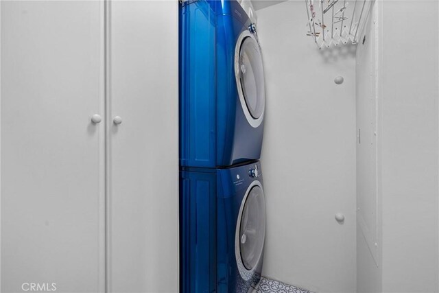 washroom featuring stacked washer and clothes dryer