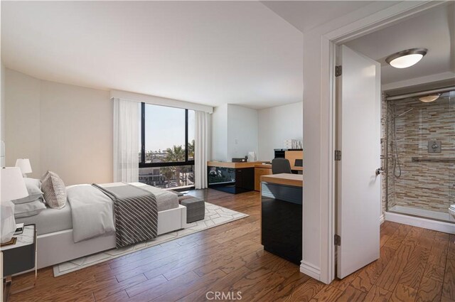 bedroom with a wall of windows, access to exterior, and dark hardwood / wood-style floors