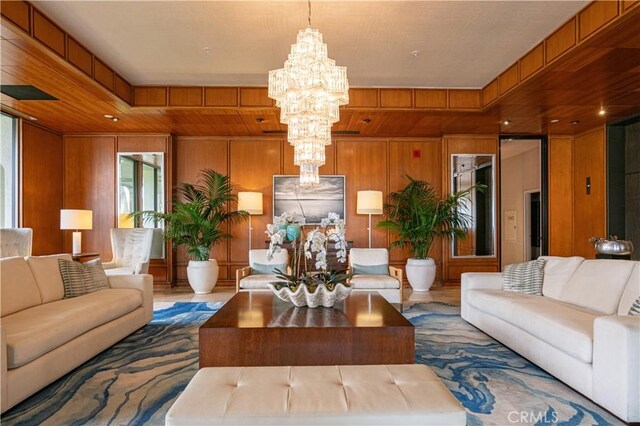 living area with a chandelier and wood walls