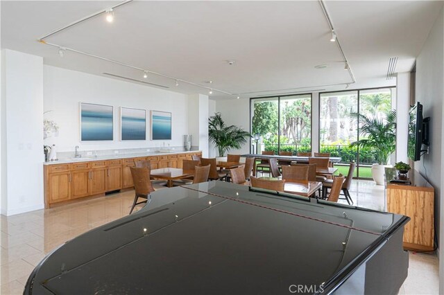 playroom featuring light tile patterned floors, floor to ceiling windows, track lighting, and a sink