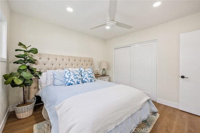 bedroom with ceiling fan, wood-type flooring, and a closet