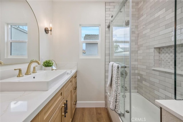 bathroom with vanity, enclosed tub / shower combo, and wood-type flooring