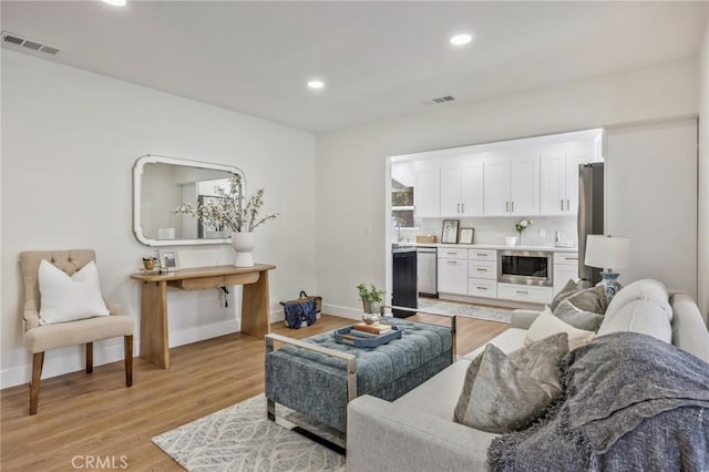 living room featuring sink and light hardwood / wood-style floors