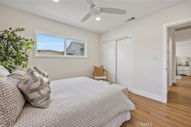 bedroom featuring light hardwood / wood-style flooring, a closet, and ceiling fan