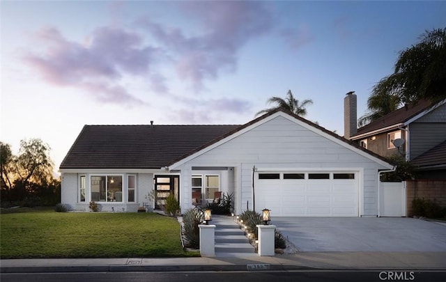 view of front of property with a garage and a lawn