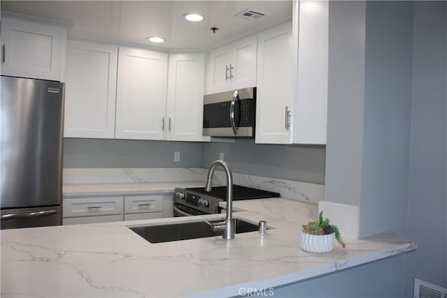 525 E Seaside Way Unit 1504, Long Beach, CA 90802 - kitchen with appliances with stainless steel finishes, light stone counters, white cabinets, and recessed lighting