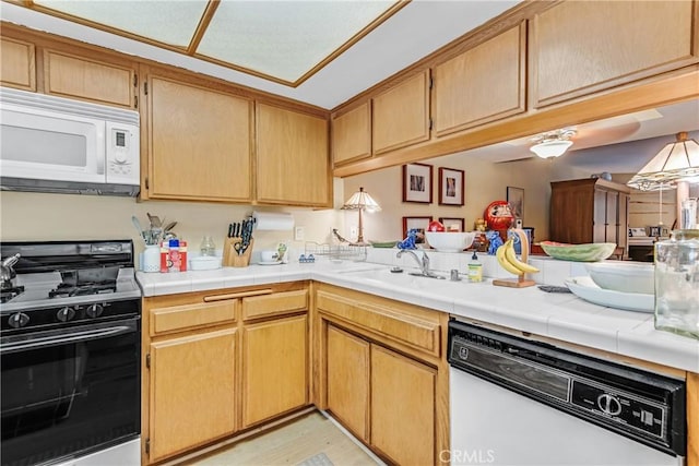 kitchen with tile counters, kitchen peninsula, and white appliances