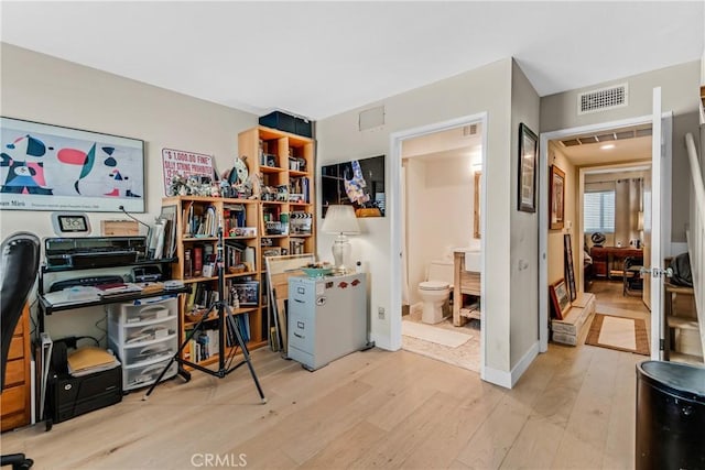 home office with light hardwood / wood-style floors