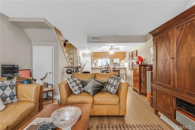 living room with light wood-type flooring and ceiling fan