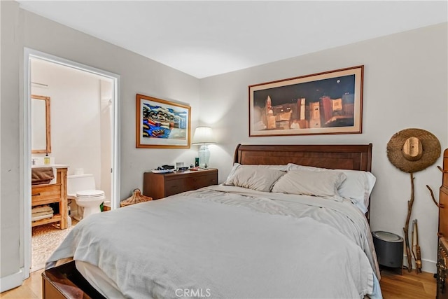 bedroom featuring ensuite bathroom and light hardwood / wood-style flooring