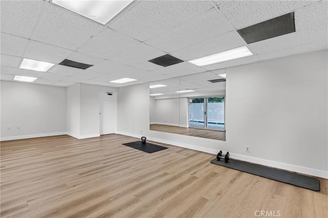 workout room featuring wood-type flooring and a drop ceiling