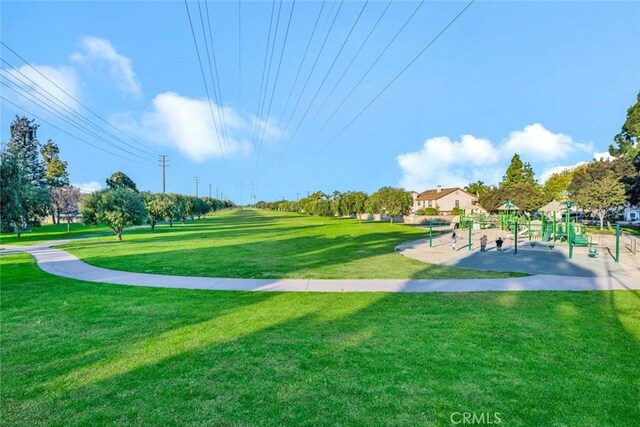 view of home's community with a playground and a yard