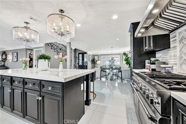 kitchen featuring a chandelier, custom range hood, a large island, decorative light fixtures, and double oven range