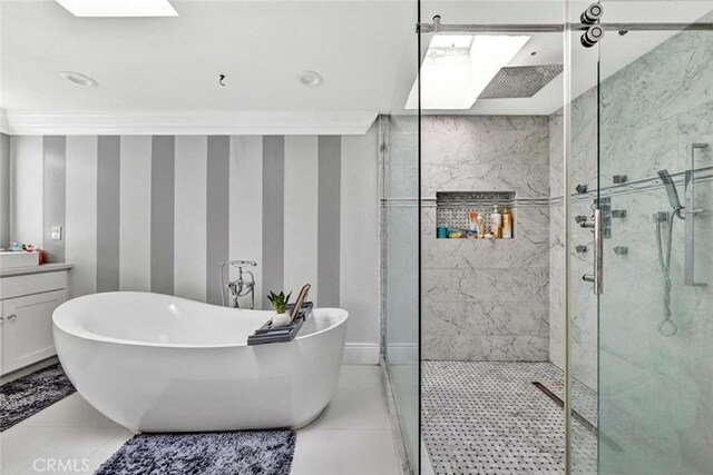 bathroom with crown molding, separate shower and tub, tile patterned floors, a skylight, and vanity