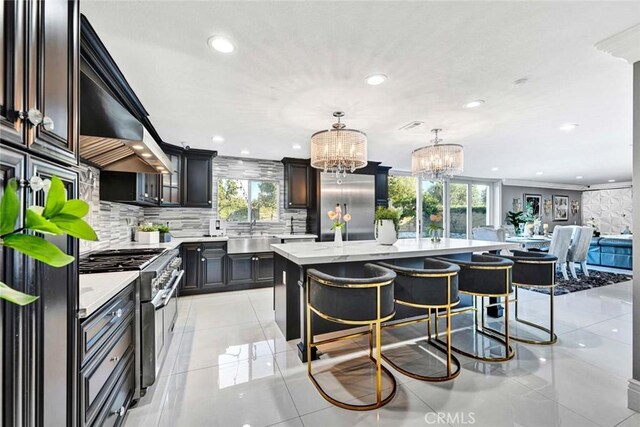 kitchen featuring a kitchen island, backsplash, hanging light fixtures, a breakfast bar area, and high quality appliances