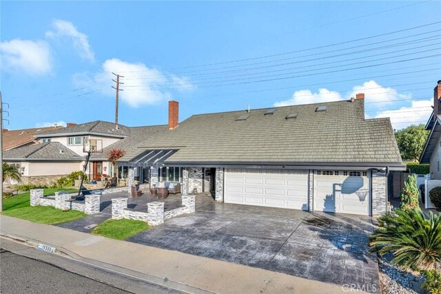 view of front of home featuring a garage and a patio