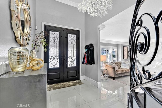 tiled entryway featuring a notable chandelier, french doors, and crown molding