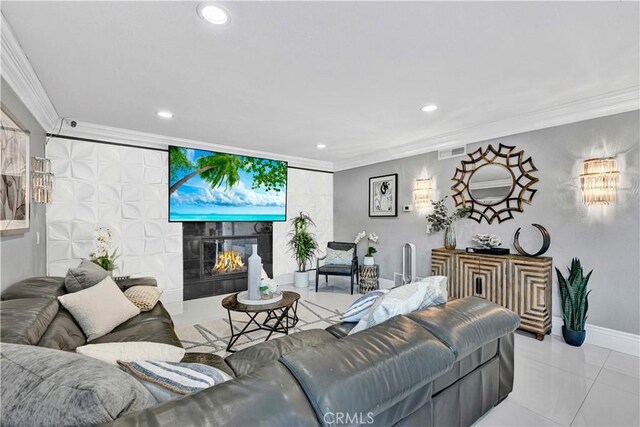 living room with a tile fireplace, light tile patterned flooring, and ornamental molding