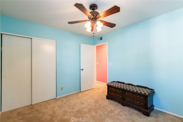 bedroom featuring light carpet, a closet, and ceiling fan