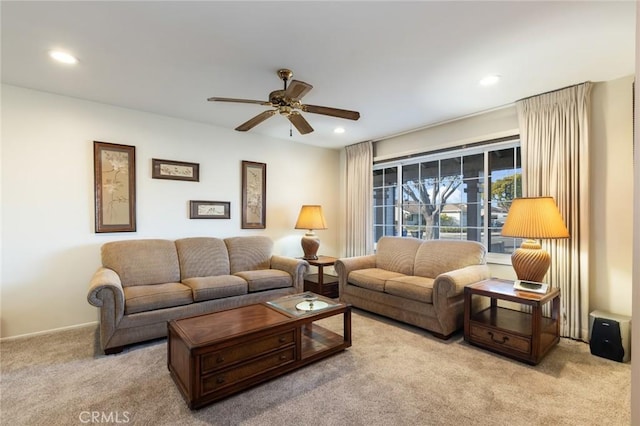 carpeted living room with ceiling fan