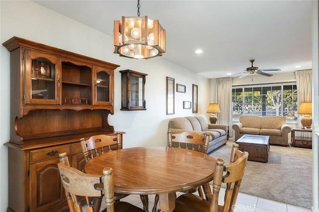 dining space featuring ceiling fan with notable chandelier and light tile patterned floors