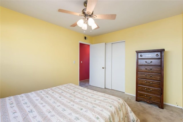 bedroom with light carpet, ceiling fan, and a closet