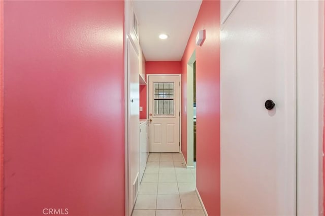 hallway with light tile patterned floors and washer / dryer