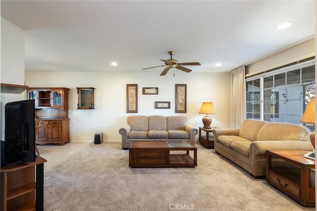 carpeted living room with ceiling fan