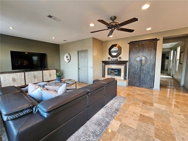 living room featuring visible vents, baseboards, a glass covered fireplace, ceiling fan, and recessed lighting