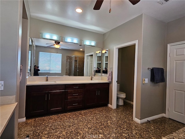 bathroom featuring double vanity, ceiling fan, baseboards, and a sink