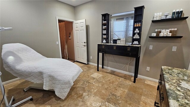 bedroom with stone finish flooring and baseboards