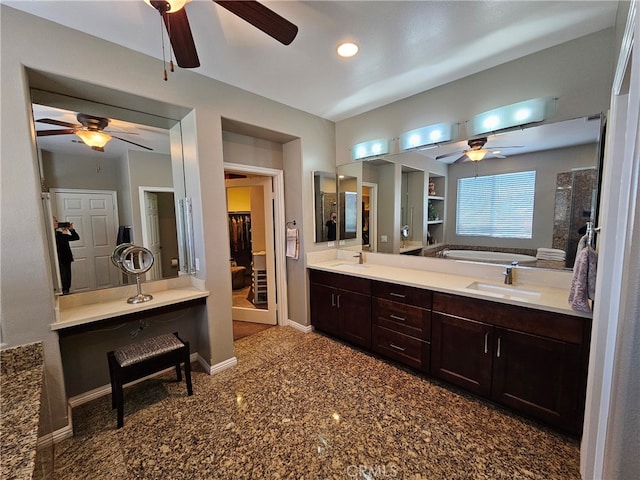 full bath with double vanity, baseboards, a sink, and a bath