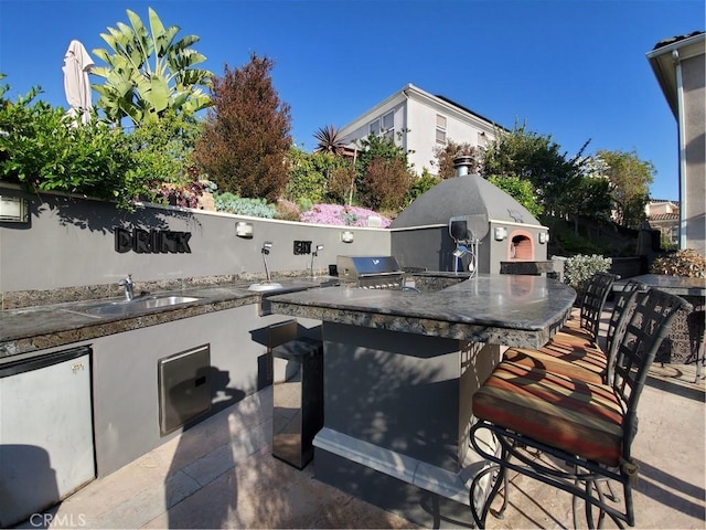 view of patio with exterior kitchen, a sink, and outdoor wet bar