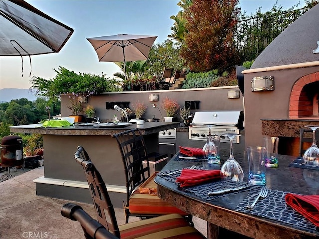 view of patio / terrace featuring exterior kitchen and a grill